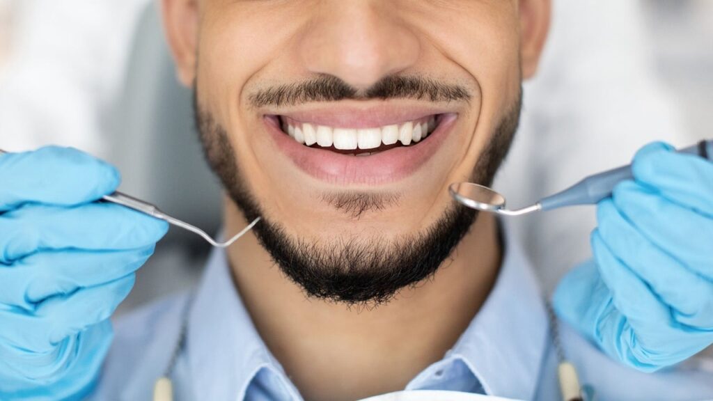 A cheerful man with a toothbrush, highlighting the importance of orthodontics and oral health.