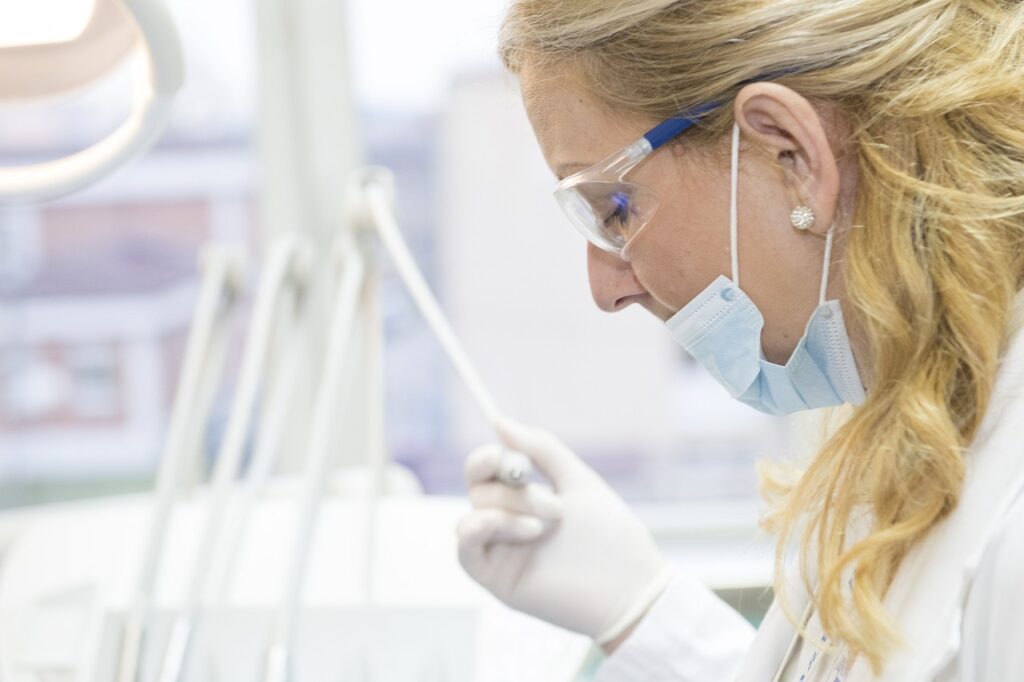 A woman at a dental office studies a toothbrush, reflecting on the importance of maintaining good dental hygiene.