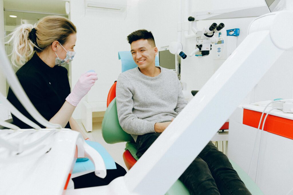 A man and woman comfortably seated in dental chairs, focusing on knocked-out tooth reimplantation options.